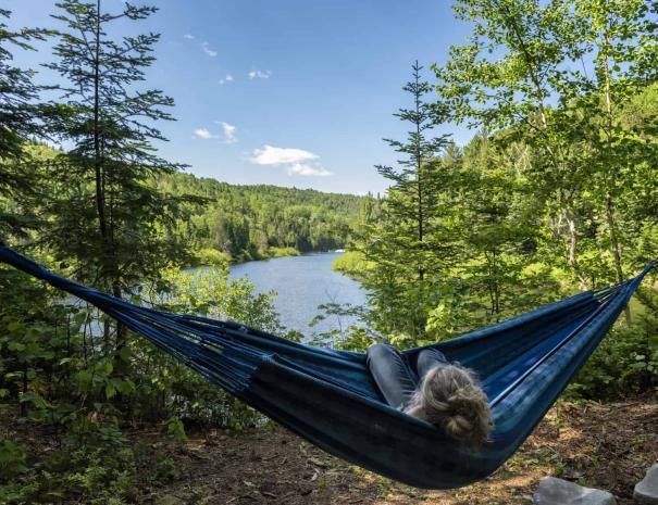 Chalet au bord de l'eau avec ressourcement thermal en forêt à St-Côme - Belvedere de relaxation avec hamacs en été