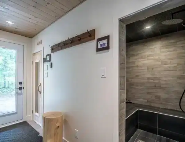 Chalet haut de gamme au bord de l'eau avec expérience thermale complète digne d’un spa nordique privé - entrée de la zone spa avec vue sur le hammam et le sauna sec