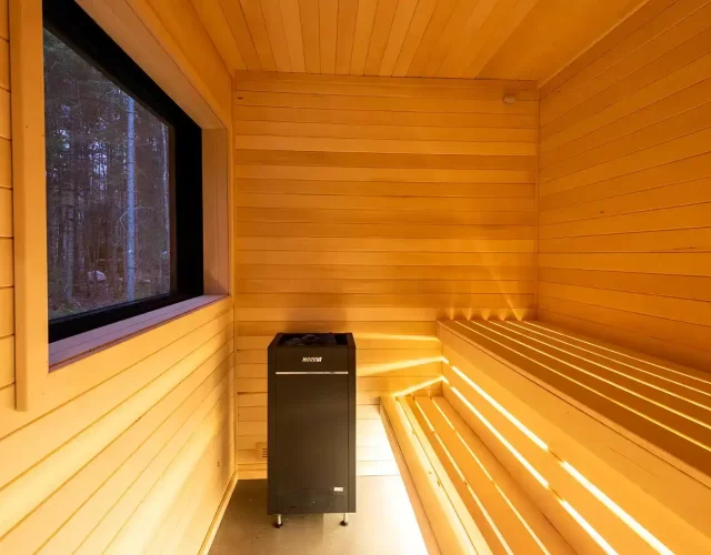 Sauna sec intérieur avec deux niveaux de bancs pouvant accomoder 4 personnes hébergement avec sauna - expérience thermale complète digne d’un spa nordique privé