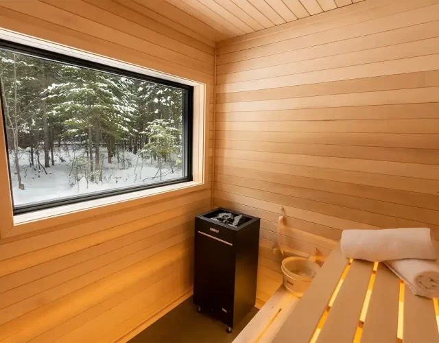 Sauna sec intérieur avec grande fenêtre et vue sur la forêt Spa et hébergement au bord de l'eau - sauna sec privé
