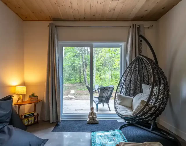 Salle de repos intérieure avec chaise hamac, bean bag et matelas de détente imperméable Chalet avec spa et sauna digne d’un spa nordique privé à Saint-Côme - salle de repos intérieure