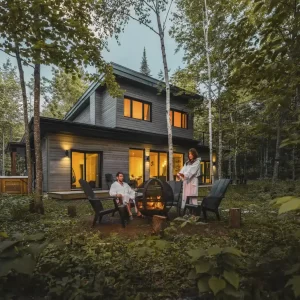 Grande cours arrière boisée et intime avec espace de feu à St-Côme Chalet au bord de l'eau avec expérience thermale complète - Grande cours arrière l'été